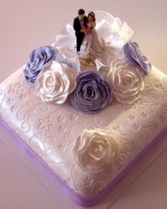 svatební dort hranatý jednopatrový s lila stuhou a bílými a fialovými růžemi z marcipánu