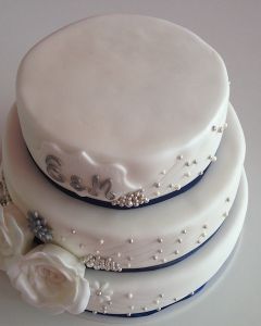 svatební dort - modrá stuha, perličky a dvě bílé růže
